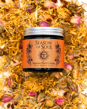 Jar of 'Season of Soul' Sunrise Face Cream surrounded by dried flowers and herbs.