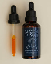 Bottle of 'Season of Soul' moonlight face oil with dropper on a beige background