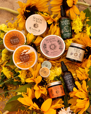Assorted skincare products with sunflowers on a wooden surface